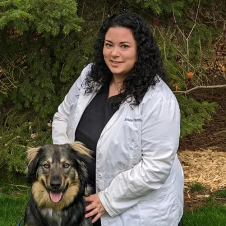 Dr. Stephanie Palumbo next to a dog outside